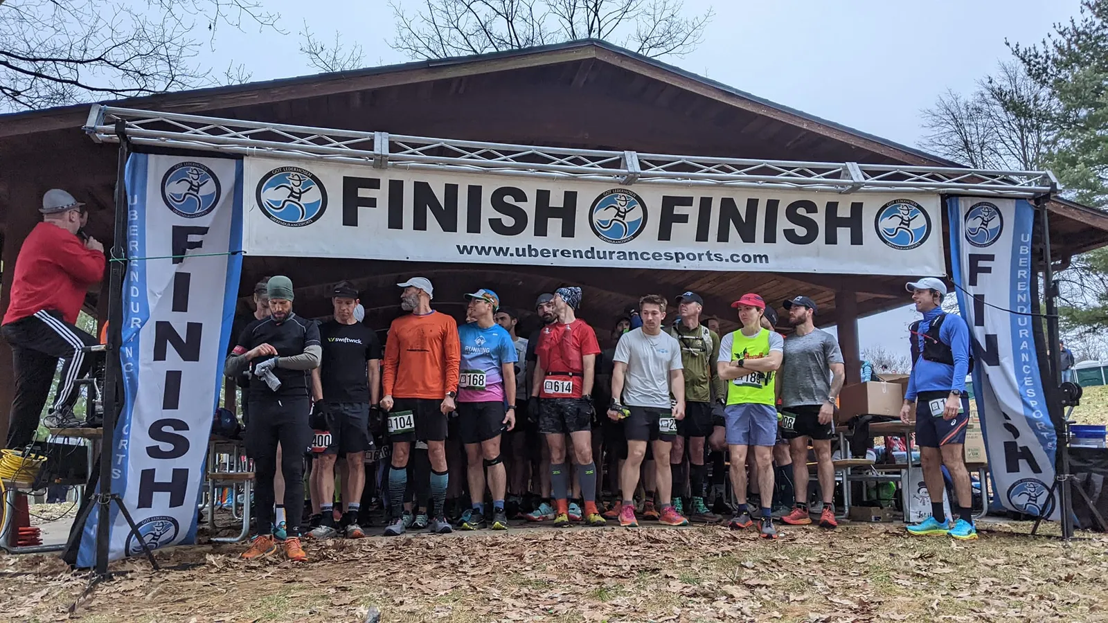 A group of runners stand at the start line under a banner that reads 'FINISH'.
