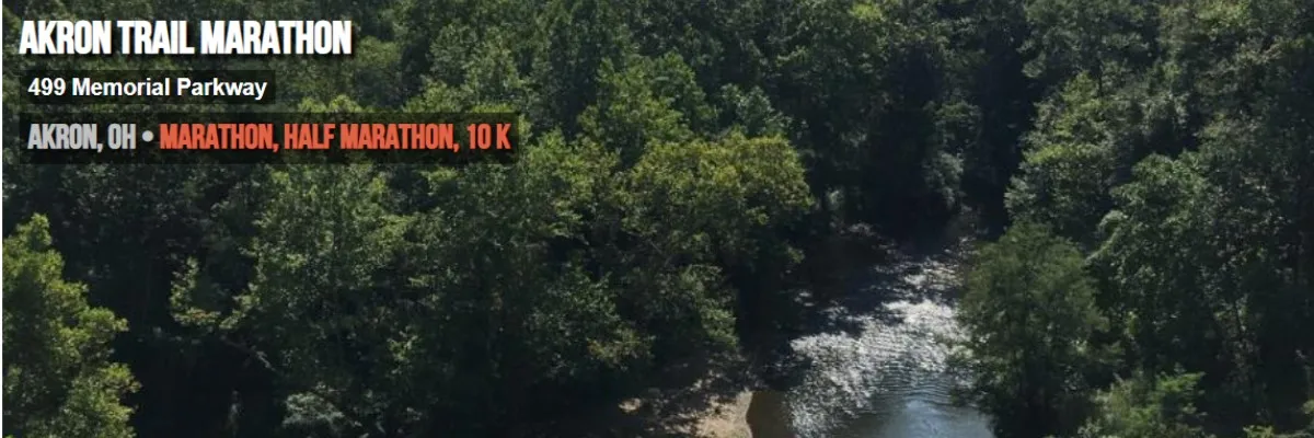 Akron Trail Marathon course view with trees and a river, featuring race title and location details.