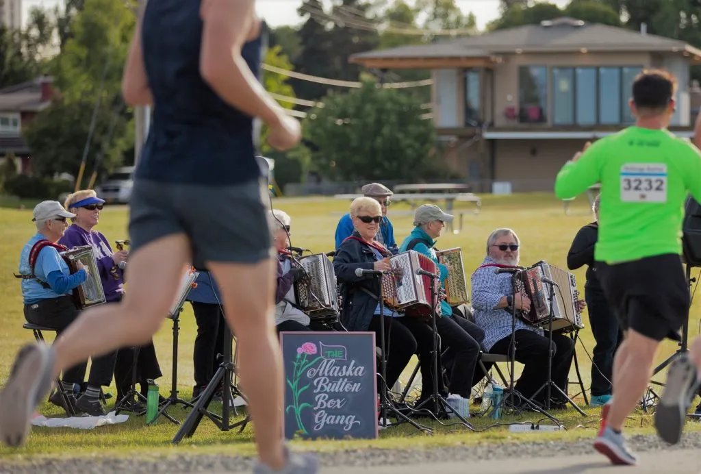 Runners pass by a group of musicians playing accordions at the Alaska Runfest.