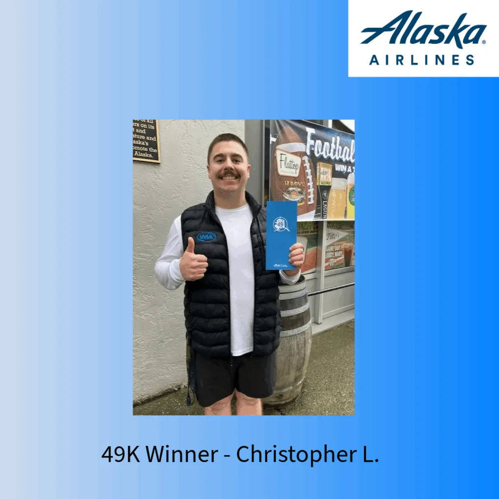Winner Christopher L. holding a blue folder and giving a thumbs up.