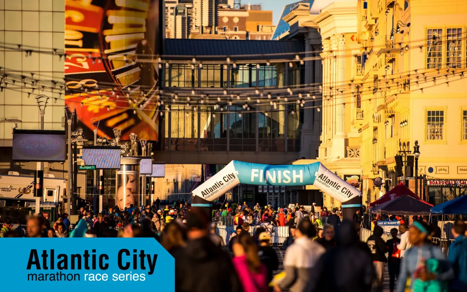 Runners crossing the finish line at the Atlantic City Marathon Race Series, with the city skyline in the background.