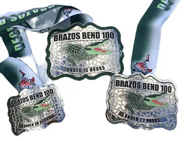 Three Brazos Bend 100 race medals with alligator graphics and ribbons.