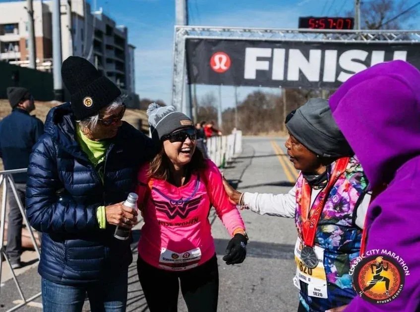 Runners celebrating at the finish line of the Classic City Marathon.