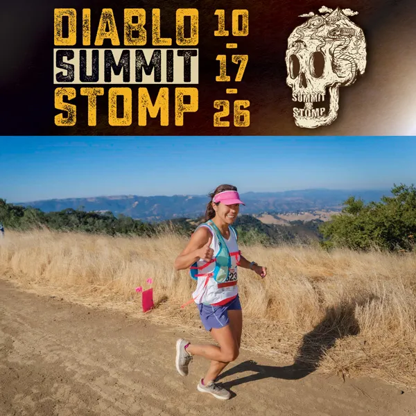 A female runner gives a thumbs up while running on a dry, grassy trail with rolling hills in the background. Race branding is visible at the top of the image.
