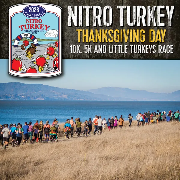 A large group of runners are seen on a grassy path next to a body of water, with hills in the distance. The top of the image has race branding and graphics.