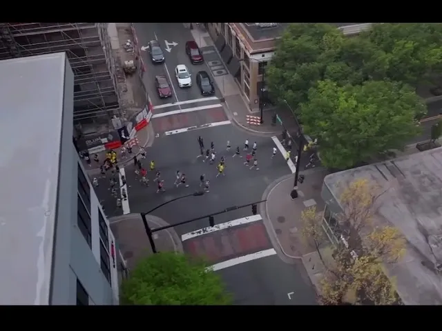 Runners navigate a city intersection during a half marathon.