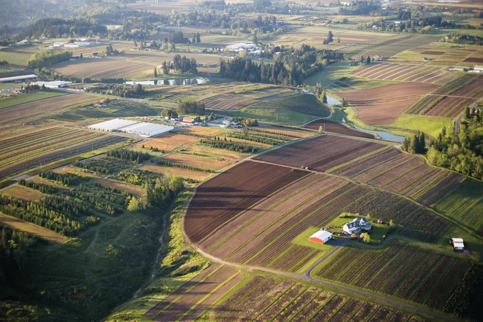Aerial view of agricultural fields and farmland, with roads winding through the landscape.