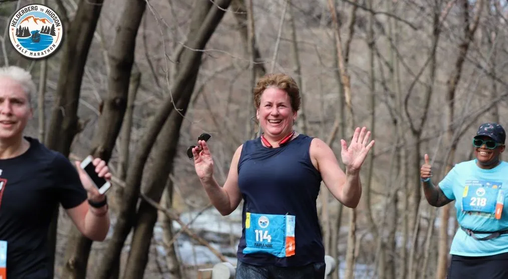 Three runners smiling and waving during the Helderberg to Hudson Half Marathon.