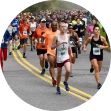 Runners in a pack on a road at the start of a race.