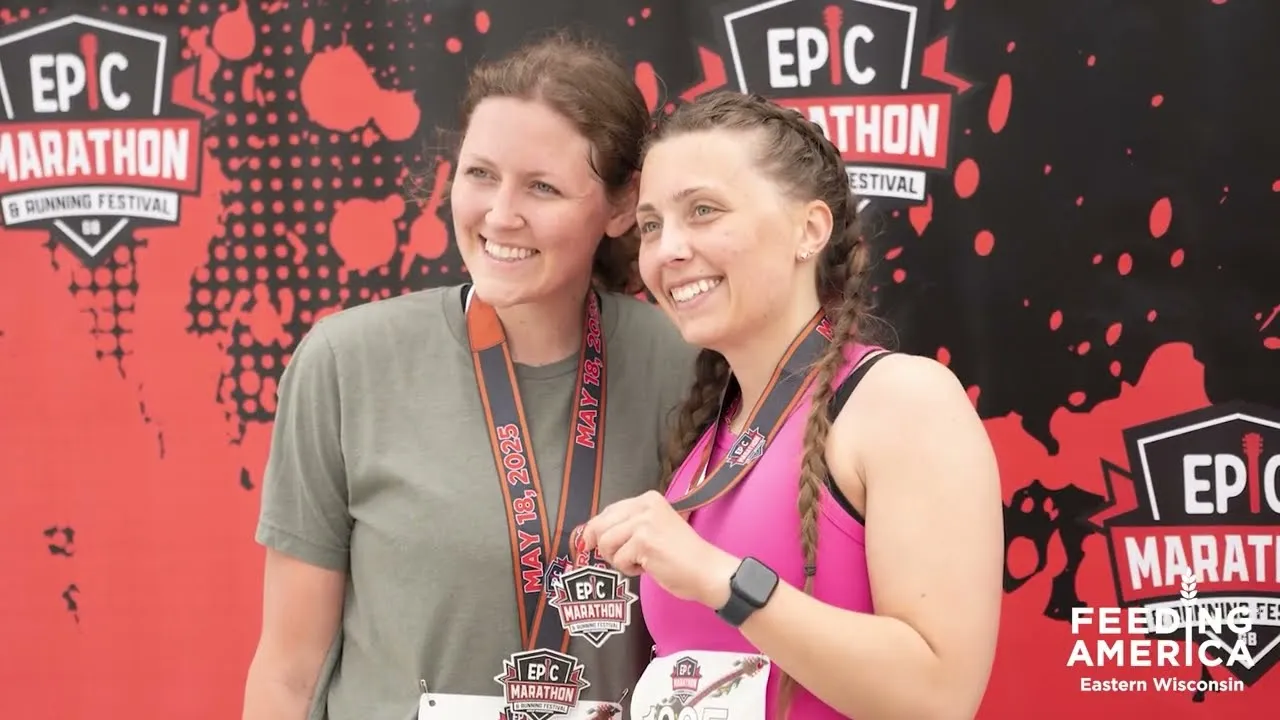Two smiling women wearing medals from the Epic Marathon & Running Festival.