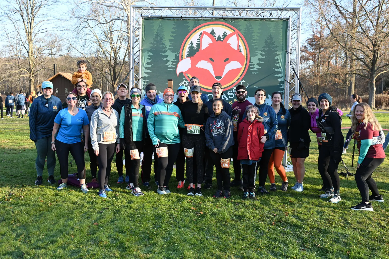 A group of runners pose for a photo in front of a large banner featuring a fox logo and the text 'FALL CLASSIC'.