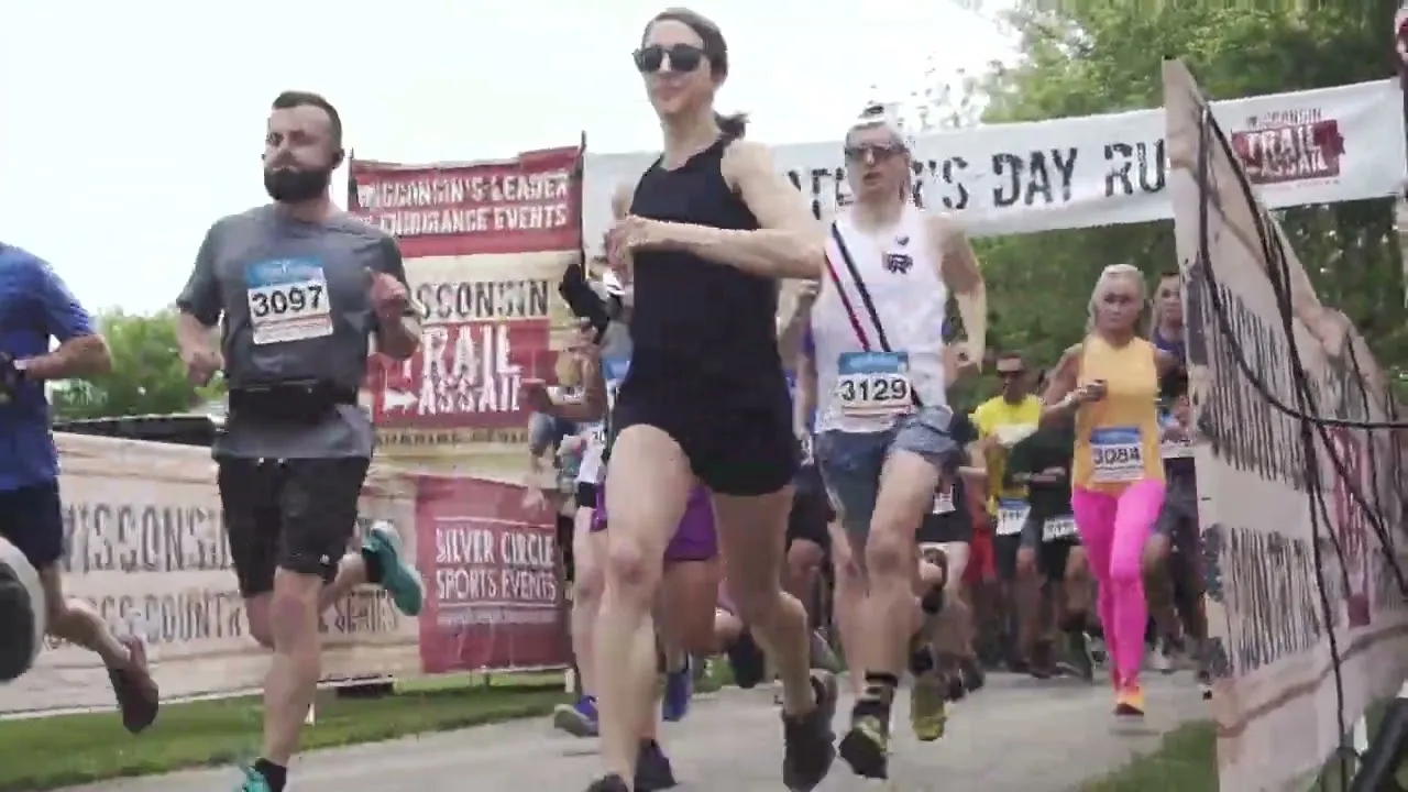 Runners starting a race, with a banner overhead that says 'Father's Day Run'.