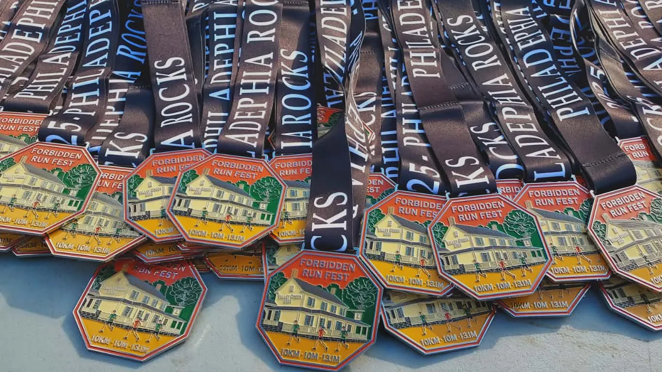 A pile of 'Forbidden Run Fest' medals with 'Philadelphia Rocks' ribbons.