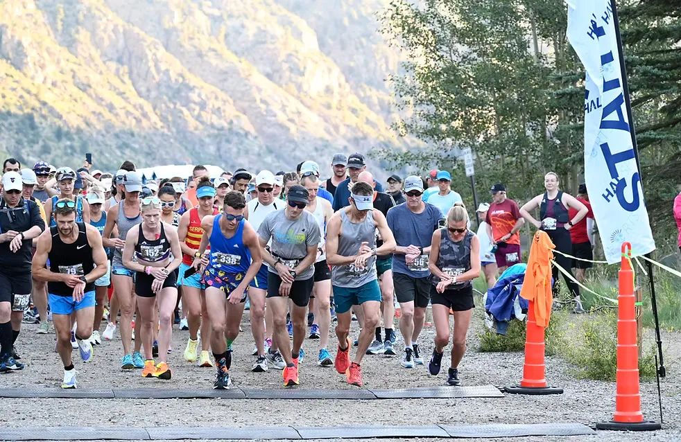 Runners starting a race with mountains in the background and a 'START' banner on the right.