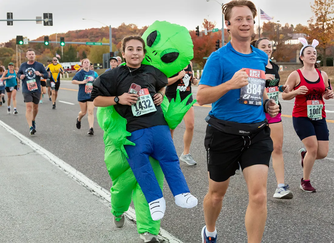 Runners in costumes, including an alien, participate in the Halloween 10k/5k race.