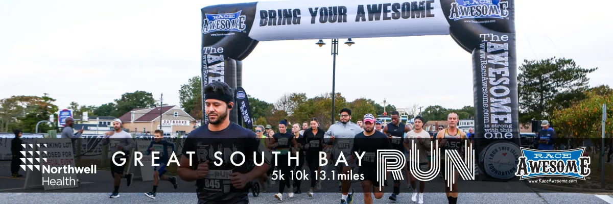 Runners starting the Great South Bay Run under an inflatable archway.