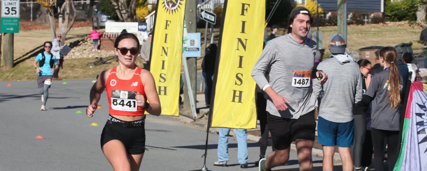 Runners approaching the finish line with yellow 'FINISH' banners.