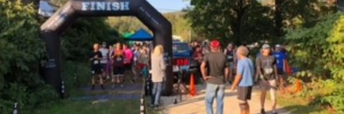 Runners approaching the finish line under an inflatable archway.