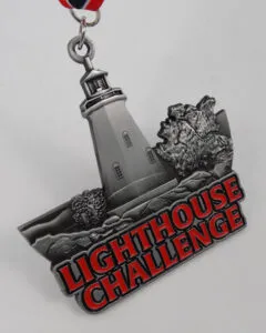 Race medal for the Lighthouse Challenge, featuring a lighthouse and rocky terrain.