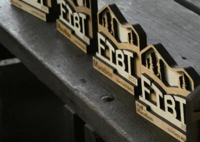 Wooden awards for the marathon, half marathon, and 5k races, with the race logo and year visible.