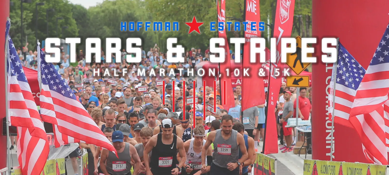 A large crowd of runners gathered at the start line of the Stars & Stripes Half Marathon, 10K & 5K, with American flags and race banners.