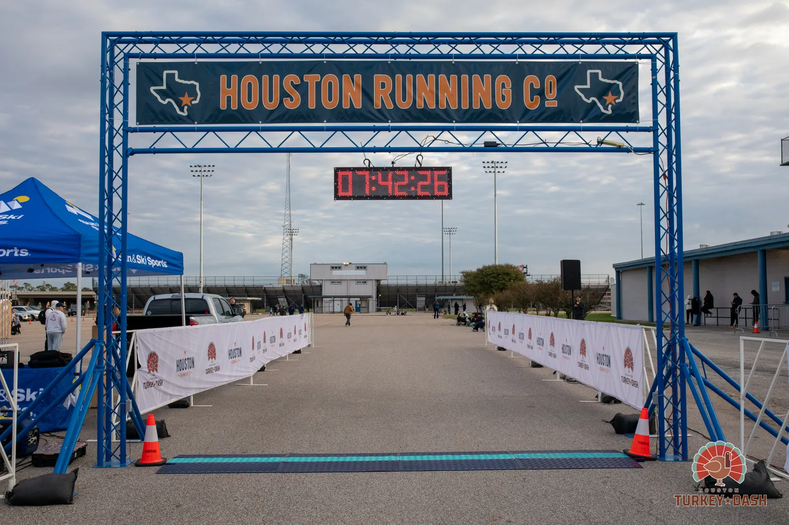 The start/finish line archway for the Houston Turkey Dash, with a digital clock displaying the time and banners lining the course.