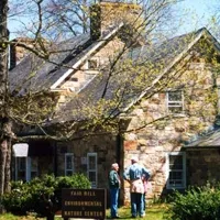Two people standing in front of the Fair Hill Environmental and Nature Center building.