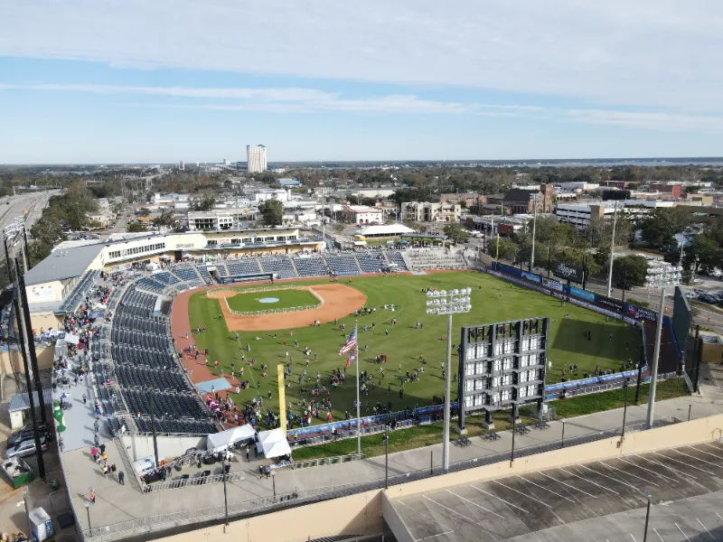 Aerial view of a baseball stadium with people gathered on the field and in the stands.