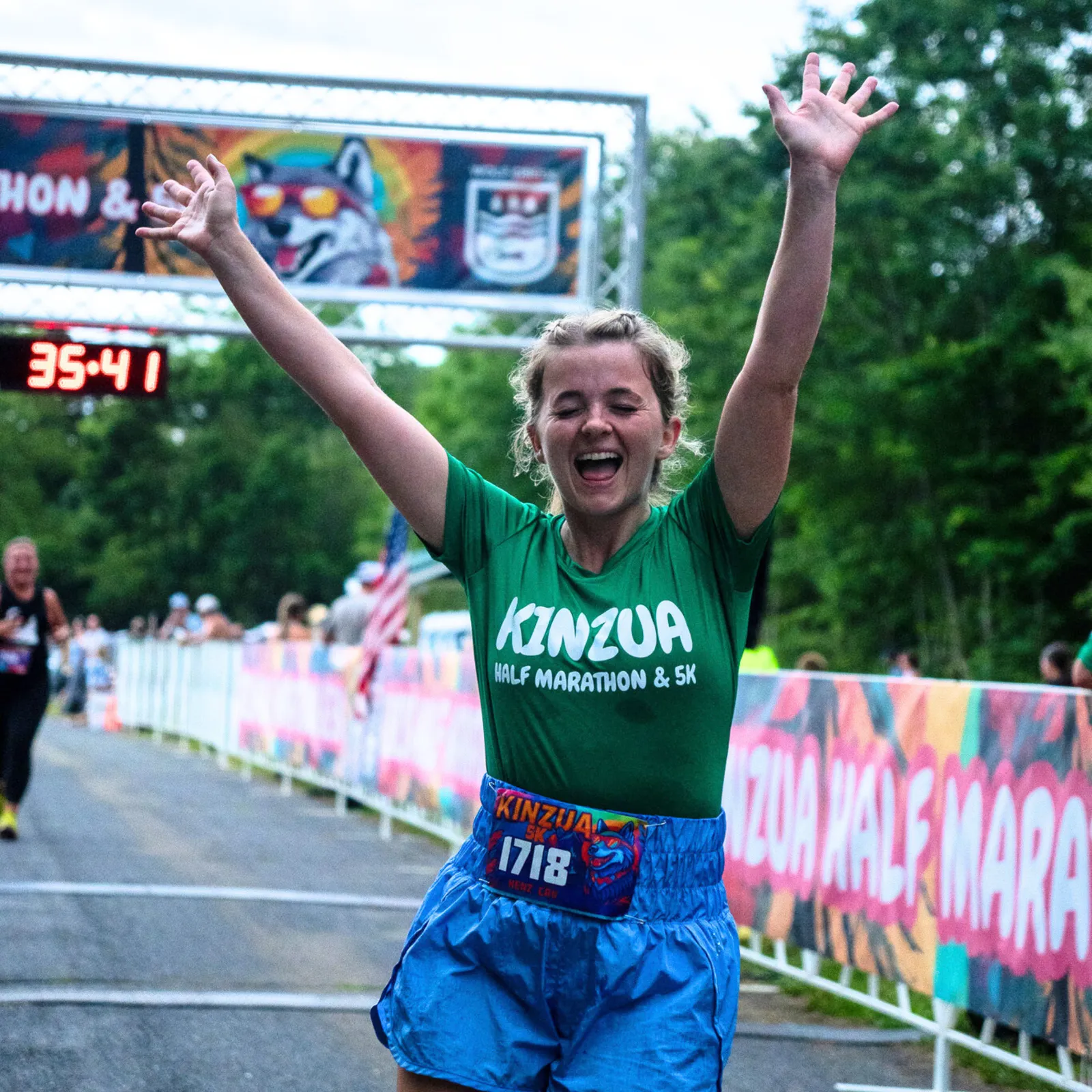 A runner with arms raised in celebration crosses the finish line at the Kinzua Half Marathon & 5K.