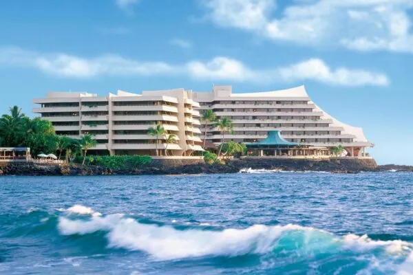 A large hotel complex on a rocky coastline with the ocean in the foreground.