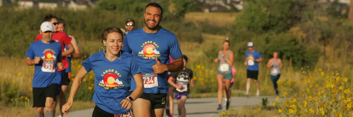 Runners participating in the Labor Day Half Marathon, with some smiling and giving a thumbs up.