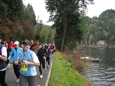 Runners participating in the Lake Samish Runs race, with a scenic view of the lake and surrounding forest.