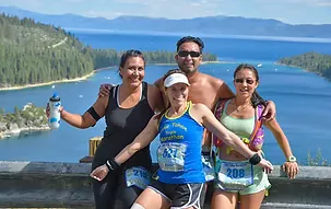 Four runners pose for a photo with Lake Tahoe in the background.