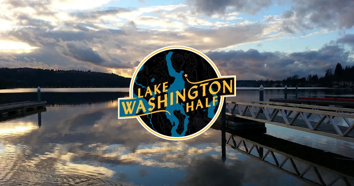 Scenic view of Lake Washington with docks and a dramatic sky, featuring the Lake Washington Half Marathon logo.
