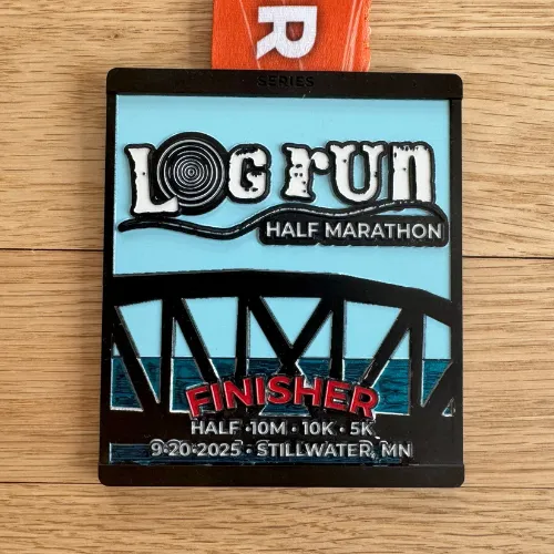 Log Run Half Marathon finisher medal with a bridge design and the date 9-20-2025.