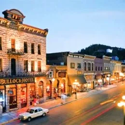 A historic street scene with old buildings and streetlights at dusk.
