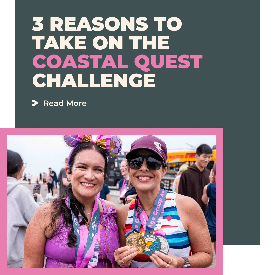 Two women smiling and showing off their race medals after completing the Coastal Quest Challenge.