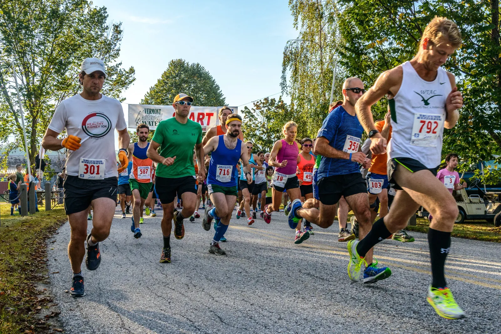 Runners starting the Maple Leaf Half Marathon, with several participants in the foreground and a banner in the background.