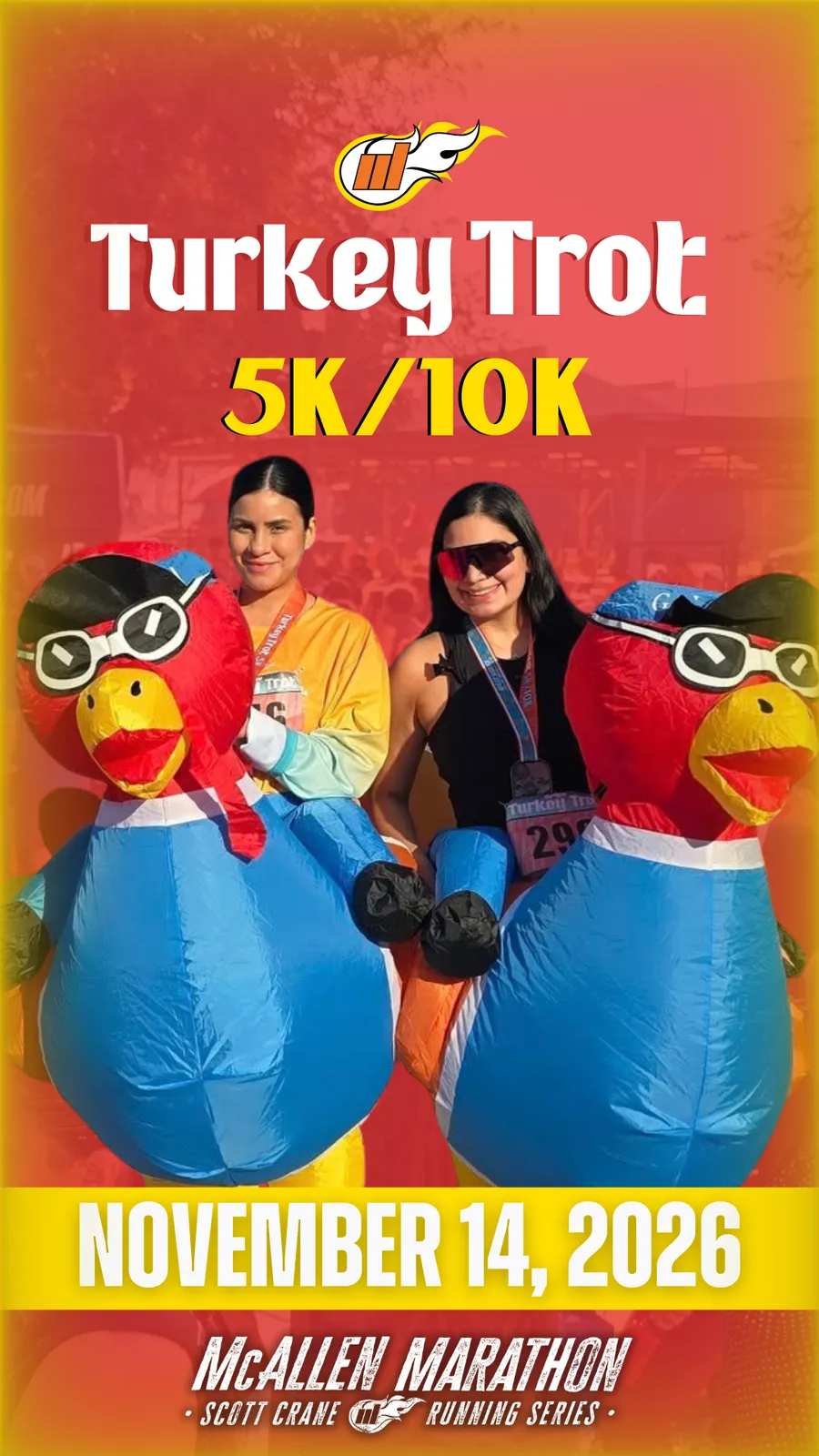 Two women smiling and posing with inflatable turkey mascots at the Turkey Trot 5K/10K race on November 14, 2026.
