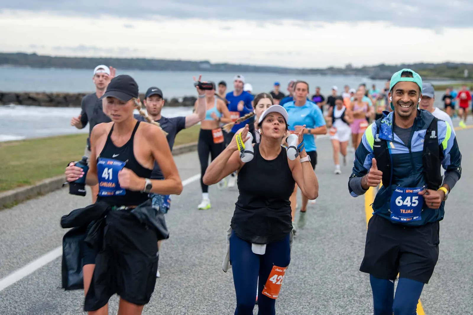 Runners participating in a half marathon with a waterfront view in the background.