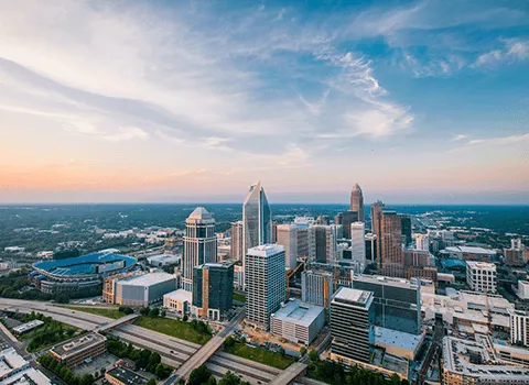 Aerial view of the Charlotte, North Carolina skyline at sunset.