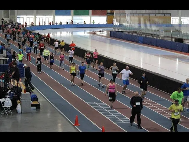 Runners competing on an indoor track during a race.