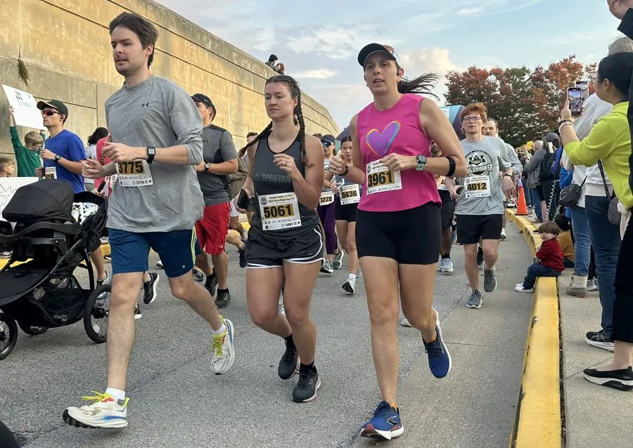 Runners participating in the Purdue Boilermaker Half Marathon & 5K, with bib numbers visible.