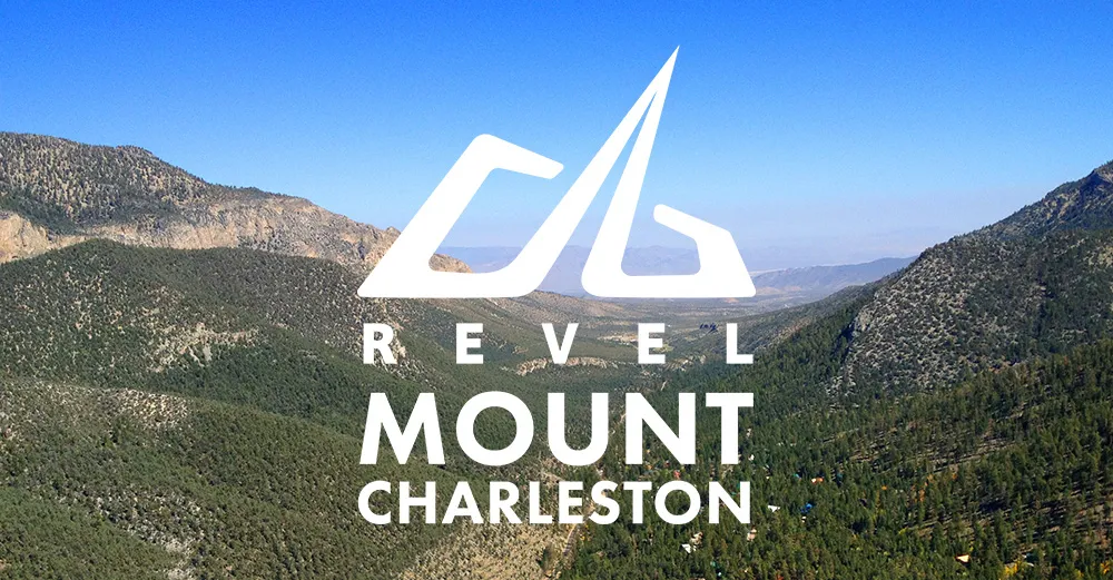 Scenic view of mountains and forest with Revel Mount Charleston text overlay.