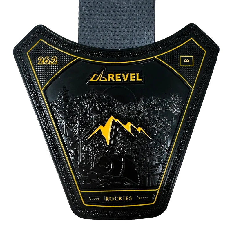 Black and gold Revel Rockies 26.2 marathon medal featuring a mountain landscape.