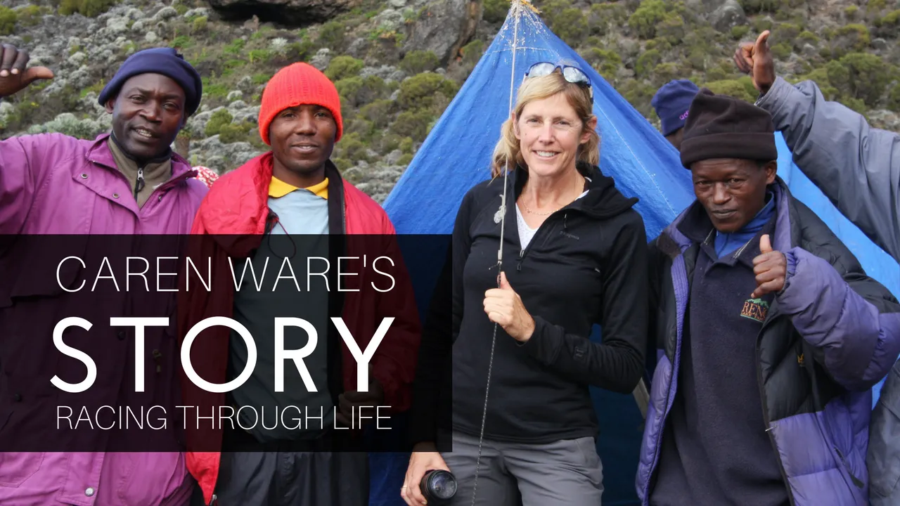 A group of people, including a woman and several men, smiling and giving thumbs up in front of a blue tent, with text overlay 'CAREN WARE'S STORY RACING THROUGH LIFE'.