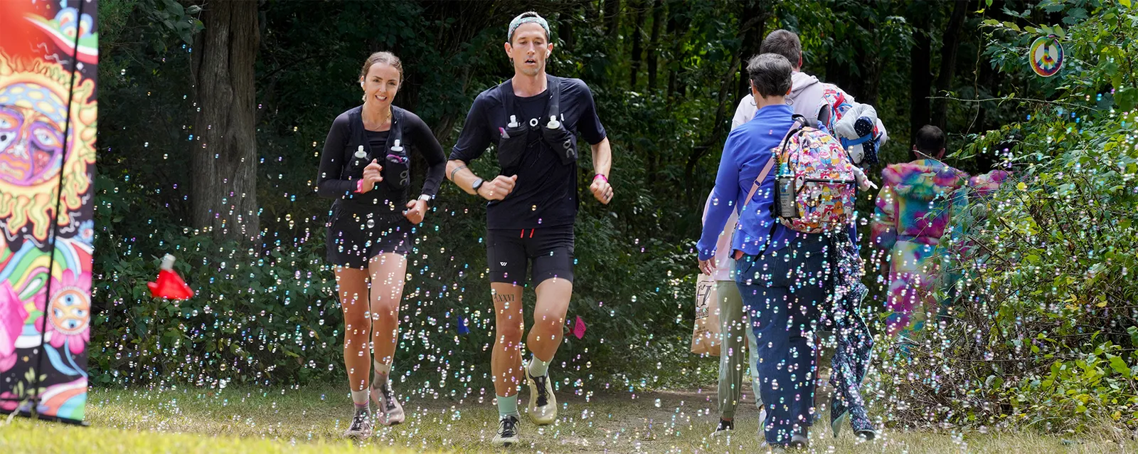 Runners participating in a race, with bubbles floating in the air and colorful decorations visible on the side.