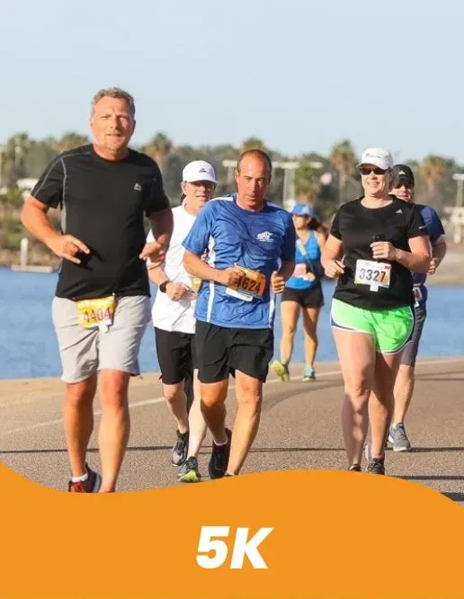 Runners participating in a race, with a focus on their mid-sections and legs as they run on a paved path.