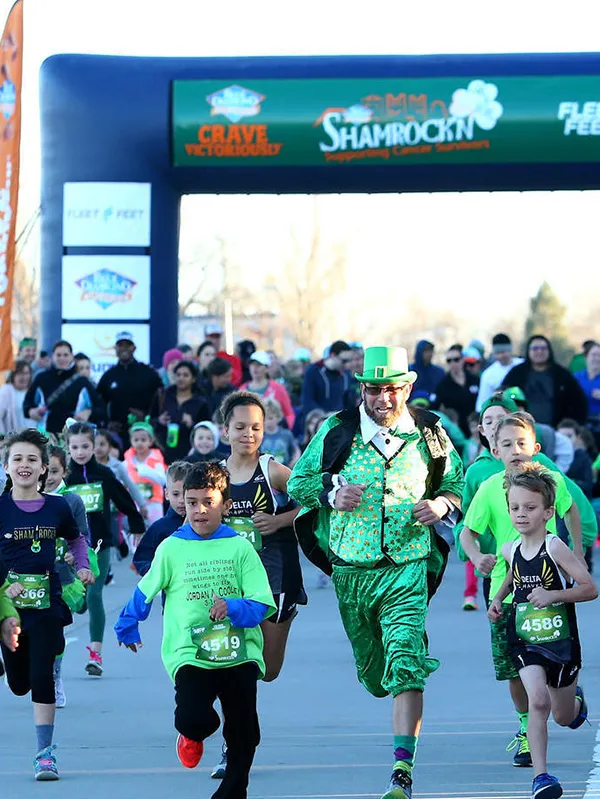 Runners, including one in a green leprechaun costume, start the Shamrock 'n' Half Marathon.