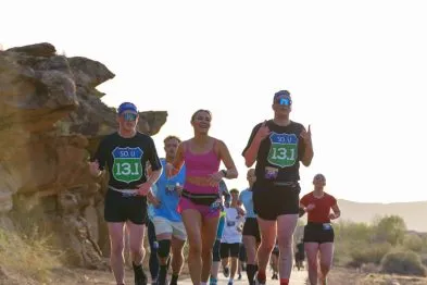 Runners participating in the Southern Utah Half Marathon, with a scenic desert landscape in the background.